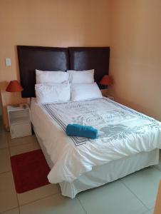 a bedroom with a large bed with white sheets and pillows at Ngena guesthouse in Cape Town