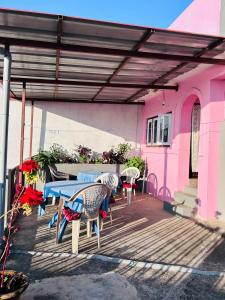 un patio con mesa y sillas y una casa rosa en City View Home Stay en Tānsen
