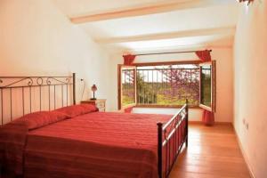 a bedroom with a bed and a large window at La Ripa Del Drago in Bibbona