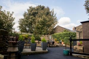 a courtyard with potted plants and a fence at The Rose Bed and Breakfast in Stainland