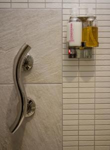 baño con dispensador en una pared de azulejos en The Rose Bed and Breakfast, en Stainland