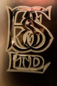 um close-up de um sinal de metal que saysrd em The Rose Bed and Breakfast em Stainland