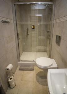 a bathroom with a shower and a toilet and a sink at The Rose Bed and Breakfast in Stainland