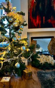 Un arbre de Noël avec des cadeaux sous le sol dans l'établissement Grand et superbe T3 : Au cœur du Centre Ville, à Clermont-Ferrand