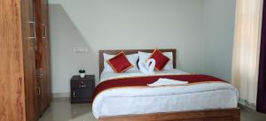 um quarto com uma cama com almofadas vermelhas e brancas em Breezeland holidays em Padinjarathara