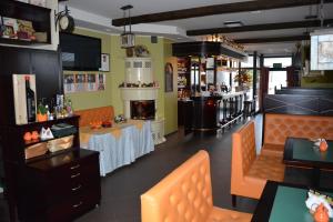 a restaurant with a bar with orange chairs and tables at Tenis Club in Kędzierzyn-Koźle