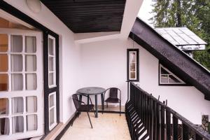 een balkon van een huis met een tafel en stoelen bij Mountain Breeze in Predeal