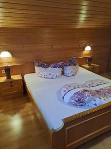 2 Betten in einem Zimmer mit Holzwänden in der Unterkunft Ferienwohnung Nancy in Jerzens