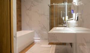 y baño blanco con lavabo y ducha. en HA Hotel Mostar en Mostar