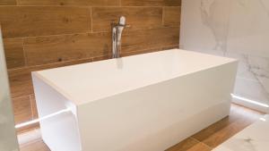 a white bathtub in a bathroom with wooden walls at HA Hotel Mostar in Mostar