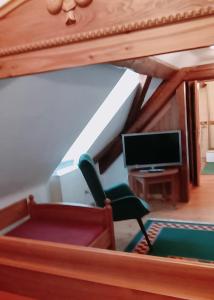 a living room with a chair and a television at Hotel garni Lindenhof im Steigerwald in Oberaurach
