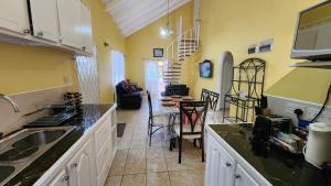 Caribbean Dream Vacation Property CD1 في جزيرة جورس: مطبخ مع حوض وطاولة مع كراسي