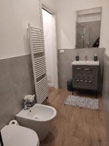 a bathroom with a white toilet and a sink at KAIROS RESIDENCE in Parma