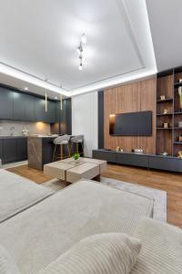 Mans lux 8 Apartman في زلاتيبور: غرفة معيشة بسريرين ومطبخ