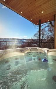 a jacuzzi tub in a house with a large window at Woodroyd apartments in Luddenden Foot