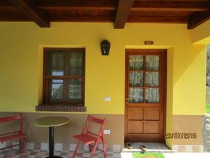 a house with two chairs and a table and a door at Agriturismo Rio Castello in Marina di Andora
