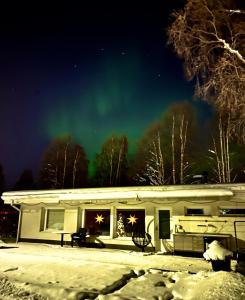 una casa con l'aurora nel cielo di Arctic River House a Rovaniemi