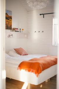 a bedroom with a bed with an orange blanket at Fjällfrid stugby in Bruksvallarna