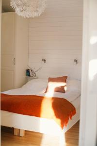 a bedroom with a large white bed with a chandelier at Fjällfrid stugby in Bruksvallarna