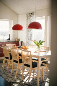 una sala da pranzo con tavolo, sedie e luci rosse di Fjällfrid stugby a Bruksvallarna