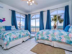 - une chambre avec 2 lits avec des rideaux bleus et une fenêtre dans l'établissement Huge luxury on the beach, à San Felipe