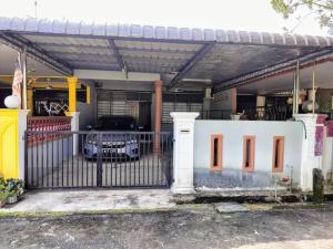 a garage with a gate with a car parked inside at Homestay D'Murni in Kampung Gurun