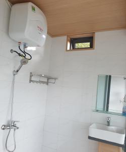 ein Bad mit einer Dusche und einem Waschbecken in der Unterkunft Tuyên Chiến Home & Resort in Ấp An Kroët