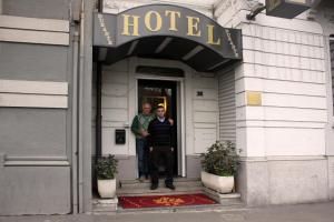 due uomini in piedi sulla porta di un hotel di Lux Hotel Durante a Milano