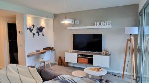 sala de estar con sofá y TV de pantalla plana en Piso Premium Vistas Mar & Golf en Mar del Plata