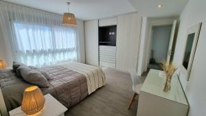 1 dormitorio con 1 cama y sala de estar con mesa en Piso Premium Vistas Mar & Golf en Mar del Plata