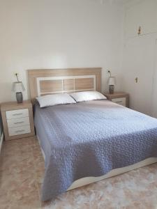 a bedroom with a large bed and two night stands at Bungalow Calpe con Piscina, Tenis, Parking in Calpe