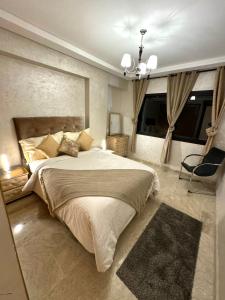 een slaapkamer met een groot bed en een kroonluchter bij Duplex Sabah Opera - Guéliz in Marrakesh