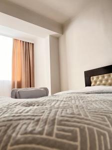 um quarto com uma cama grande e uma janela em Hyat apartment em Bishkek