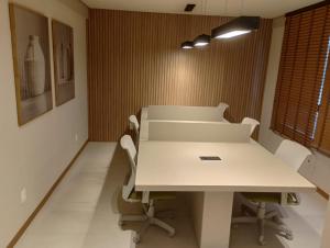 Una sala de conferencias con una mesa y sillas blancas. en Barra Stella do Mar Studio, en Salvador 15 fotos más