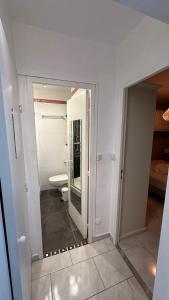 a white bathroom with a toilet and a mirror at MAZET DE LA MER 54M2 LAVANDOU 100M PLAGE avec PISCINE in Le Lavandou