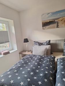 a bedroom with a bed with a blue and white blanket at Apartment Annies Deichliebe in Krummhörn