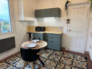 una pequeña cocina con mesa y 2 sillas en L'Escale, en Rennes