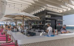 a bar on the beach with people sitting at it at Studio with pool and private beach access on Palm Jumeirah in Dubai