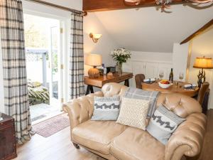 ein Wohnzimmer mit einem Sofa und einem Tisch in der Unterkunft Peony Cottage in Ulverston