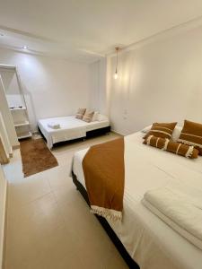 Cabaña Villa Jardín - Aldea Doradal - Santorini Colombiano في Doradal: غرفة نوم بسريرين في غرفة