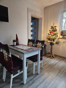 a living room with a table and a christmas tree at Serce Krynicy in Krynica Morska