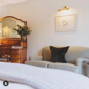 a living room with a couch and a mirror at Craigellachie Hotel of Speyside in Craigellachie