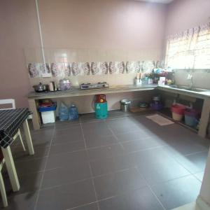 eine Küche mit Spüle und Fliesenboden in der Unterkunft Wildan Guest House Wakaf Che Yeh in Kota Bharu