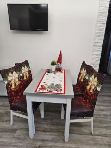 een witte tafel en twee stoelen met een tafel bij Serce Krynicy in Krynica Morska