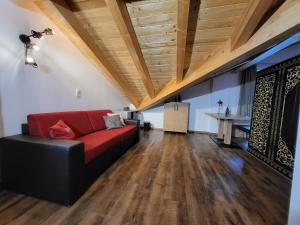a living room with a red couch and wooden ceilings at Rooftop by Northsouth Apartments in Sölden