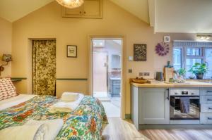 eine Küche und ein Schlafzimmer mit einem Bett in einem Zimmer in der Unterkunft The Bluebell in Bath
