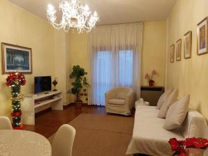 uma sala de estar com uma cama e um lustre em Da Marzia apartment em LʼAquila