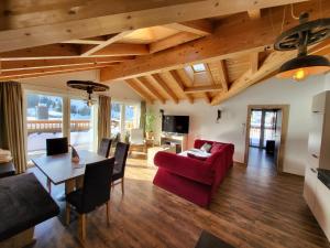 a living room with a red couch and a table at Rooftop by Northsouth Apartments in Sölden