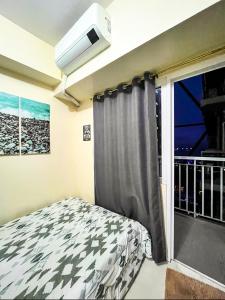 a bedroom with a bed and a window at Deluxe 1 Bedroom with Balcony Condotel in Green Residences Malate Manila near MOA and Airport in Manila