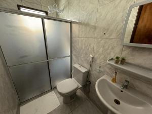 ein Bad mit einer Dusche, einem WC und einem Waschbecken in der Unterkunft Casa Costa Dourada in Porto De Galinhas